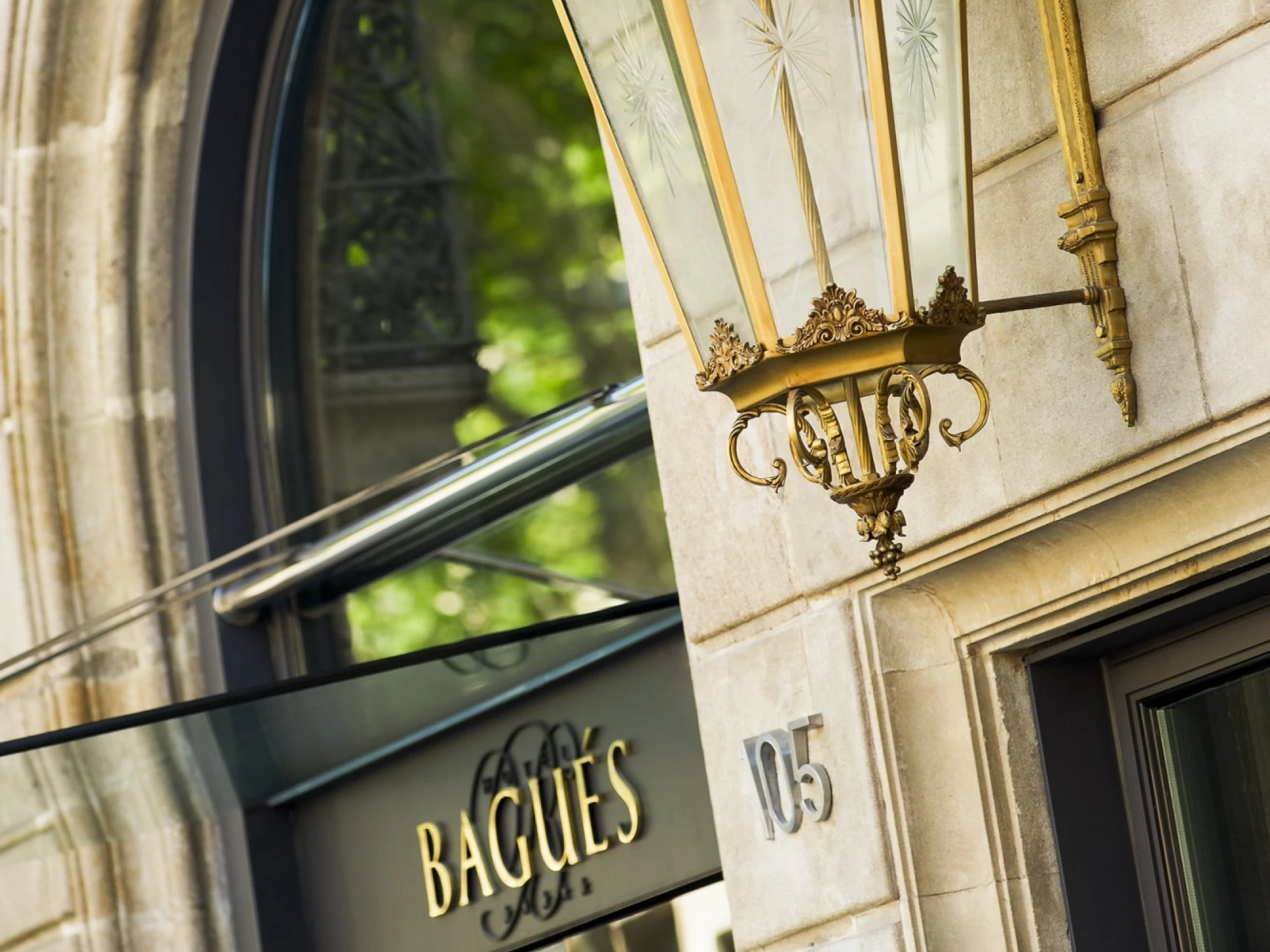 Se ve un letrero con el nombre “Bagués” sobre una fachada de piedra junto a una puerta con el número 105.