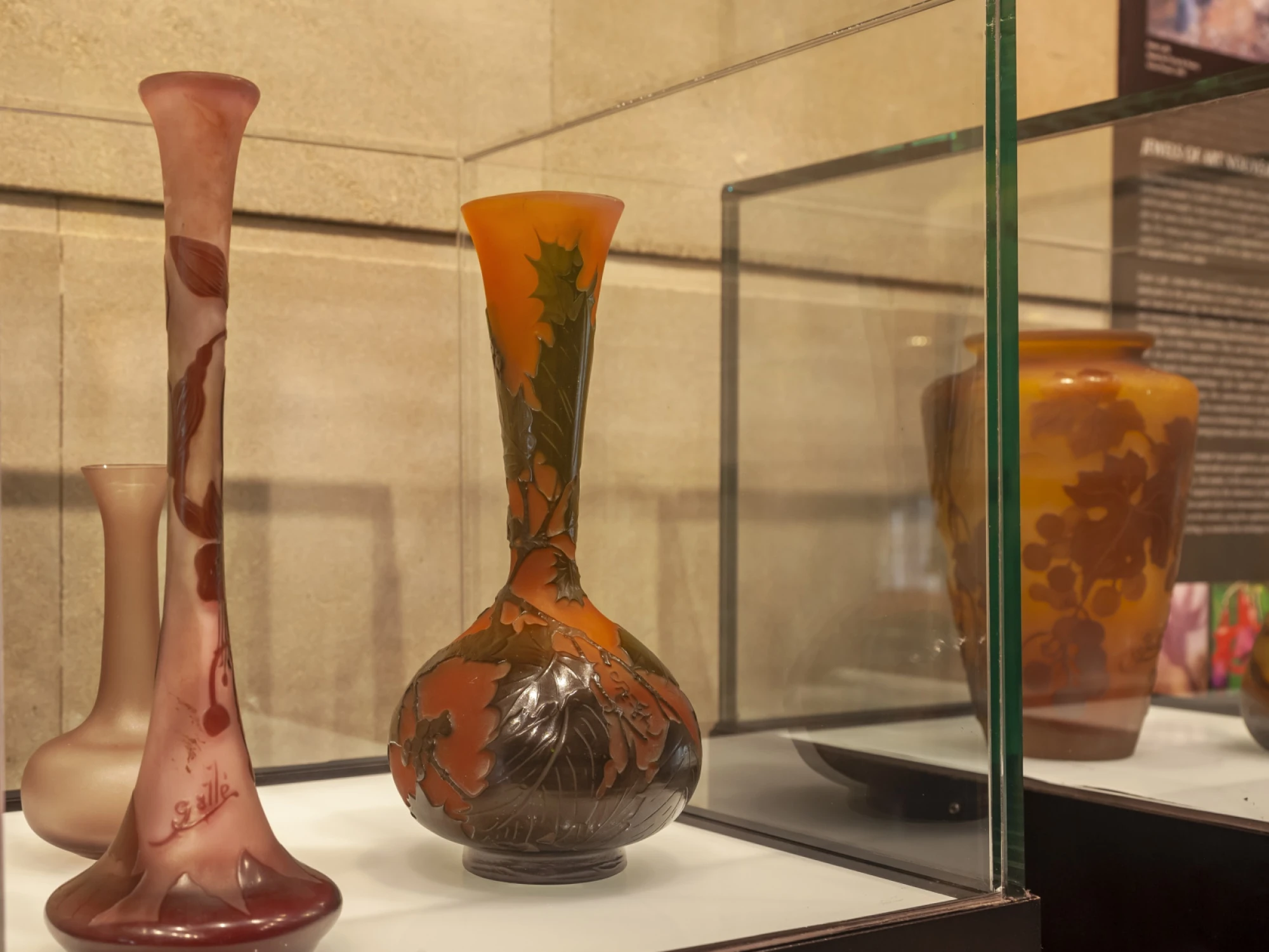 Se observan jarrones decorativos de colores dentro de una vitrina de museo.
