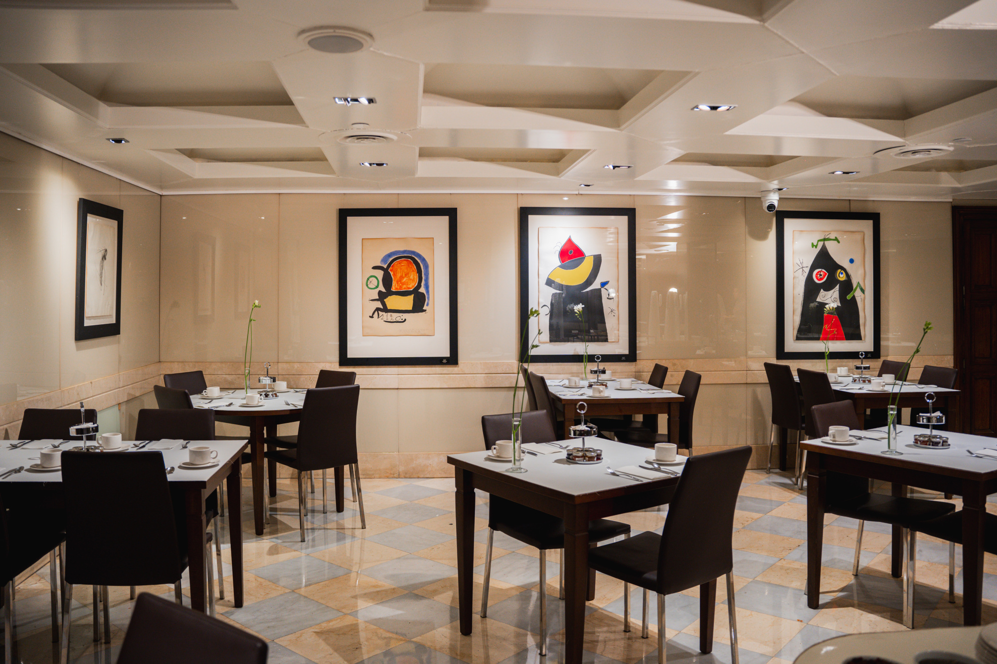 Una vista interior de un espacio de hotel con mobiliario moderno y elegante, en tonos neutros y detalles decorativos que aportan sofisticación.