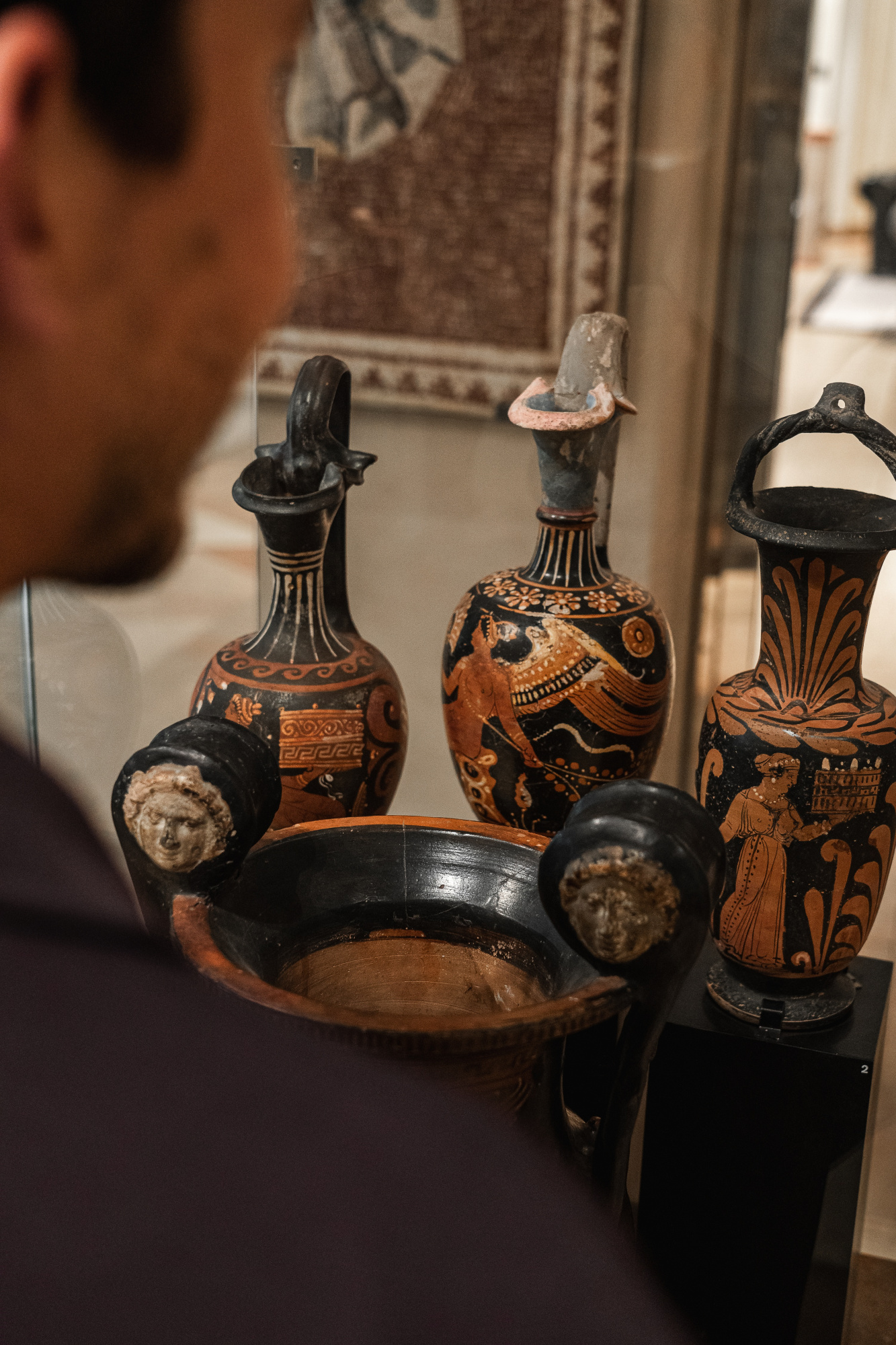 Se ven varios jarrones decorativos y objetos de cerámica sobre una mesa en un espacio interior.
