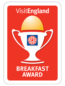 El logotipo de VisitEngland Breakfast Award aparece en un recuadro rojo con una copa y un gorro de chef.