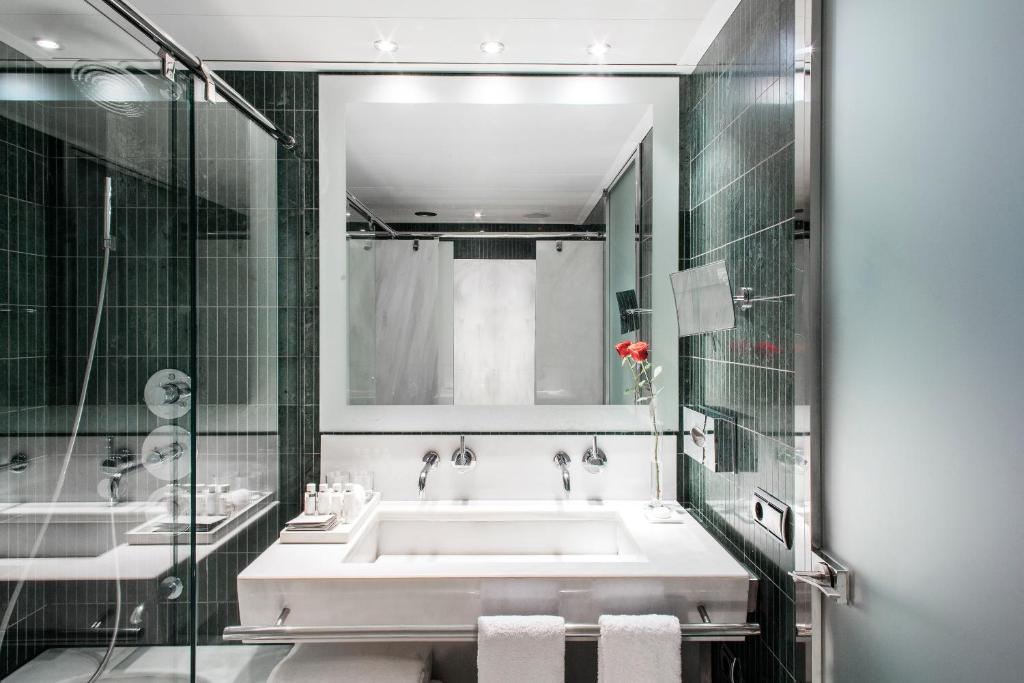 Baño moderno con bañera, ducha con mampara de vidrio y lavabos dobles