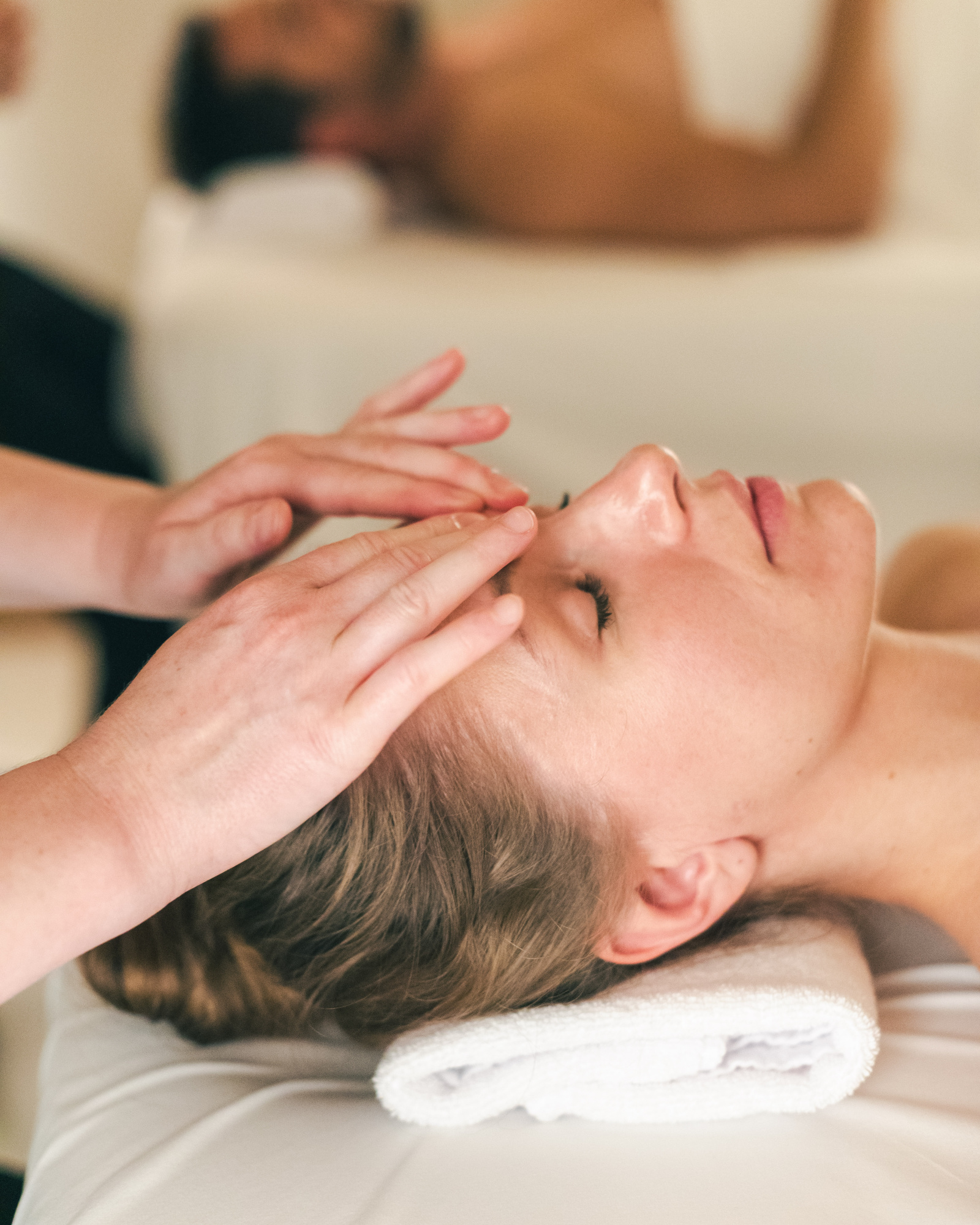 Una chica recibe un masaje relajante en la cabeza en un spa.