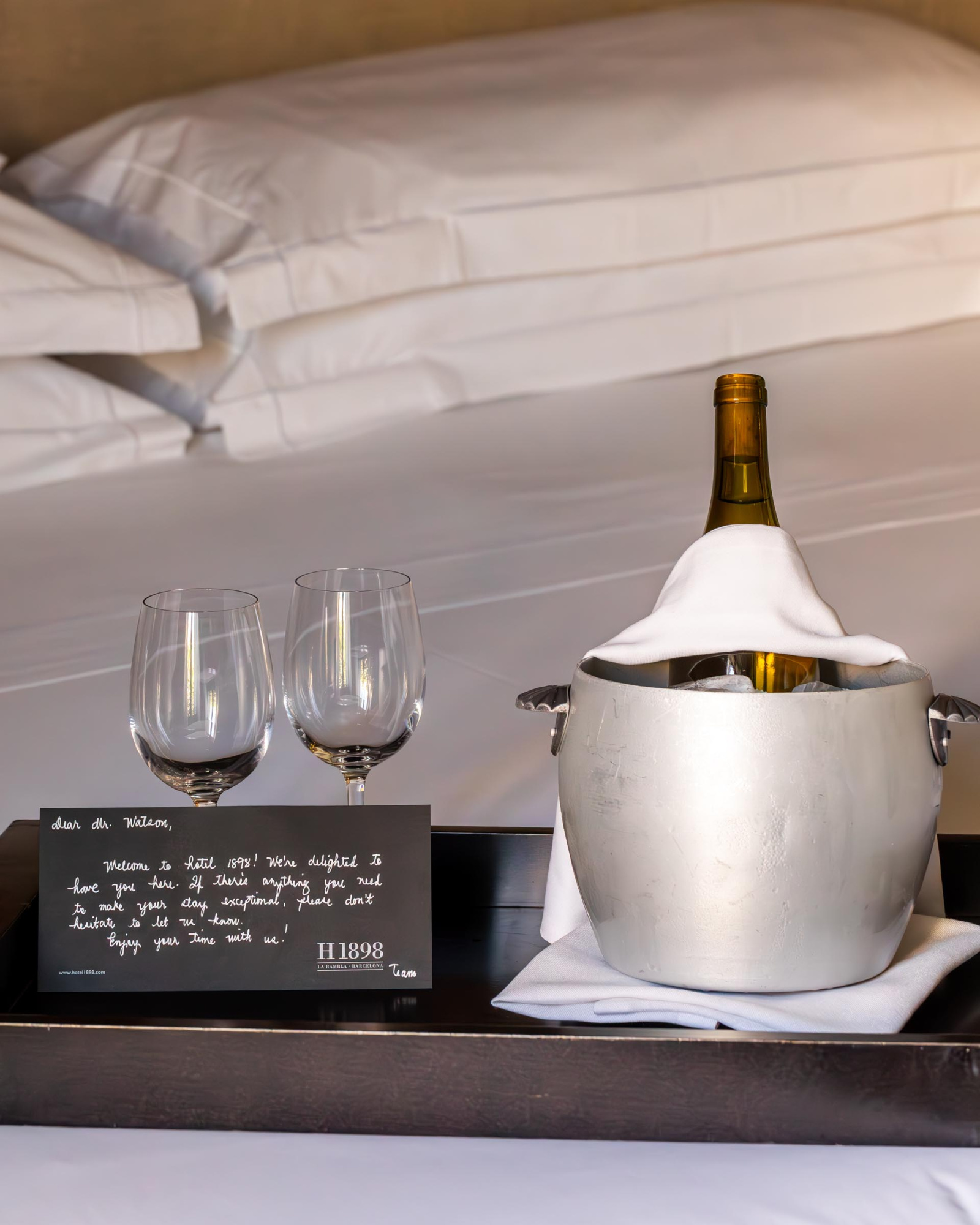 Una botella de vino de color oscuro, probablemente de vidrio, con una etiqueta visible, colocada sobre una superficie. La imagen transmite una sensación de elegancia y sofisticación, ideal para promocionar servicios de vino en un hotel.