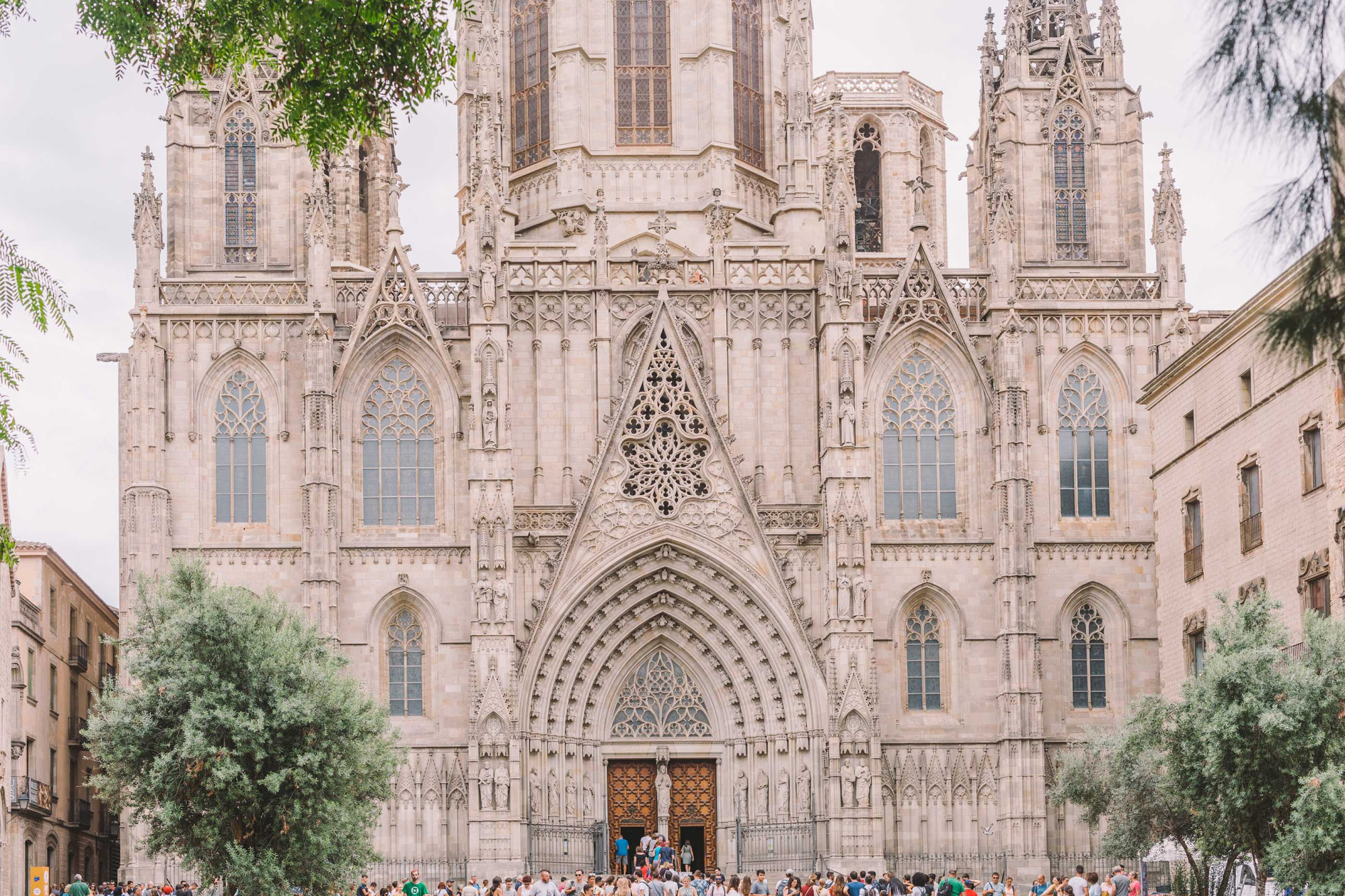Se ve la fachada de una catedral gótica con arcos, ventanas y una gran puerta central.