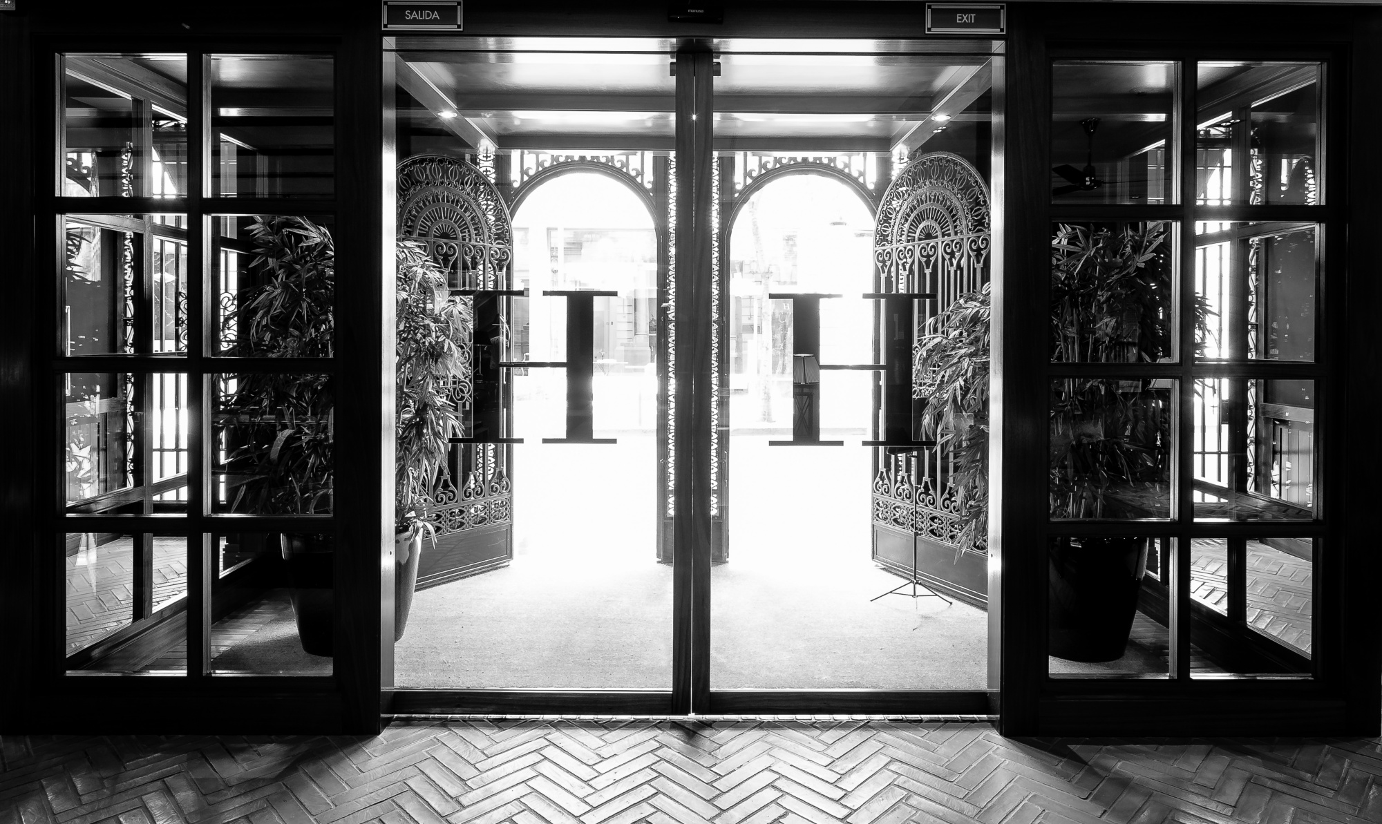 Se ve una entrada interior con puertas abiertas y arcos de piedra al fondo.