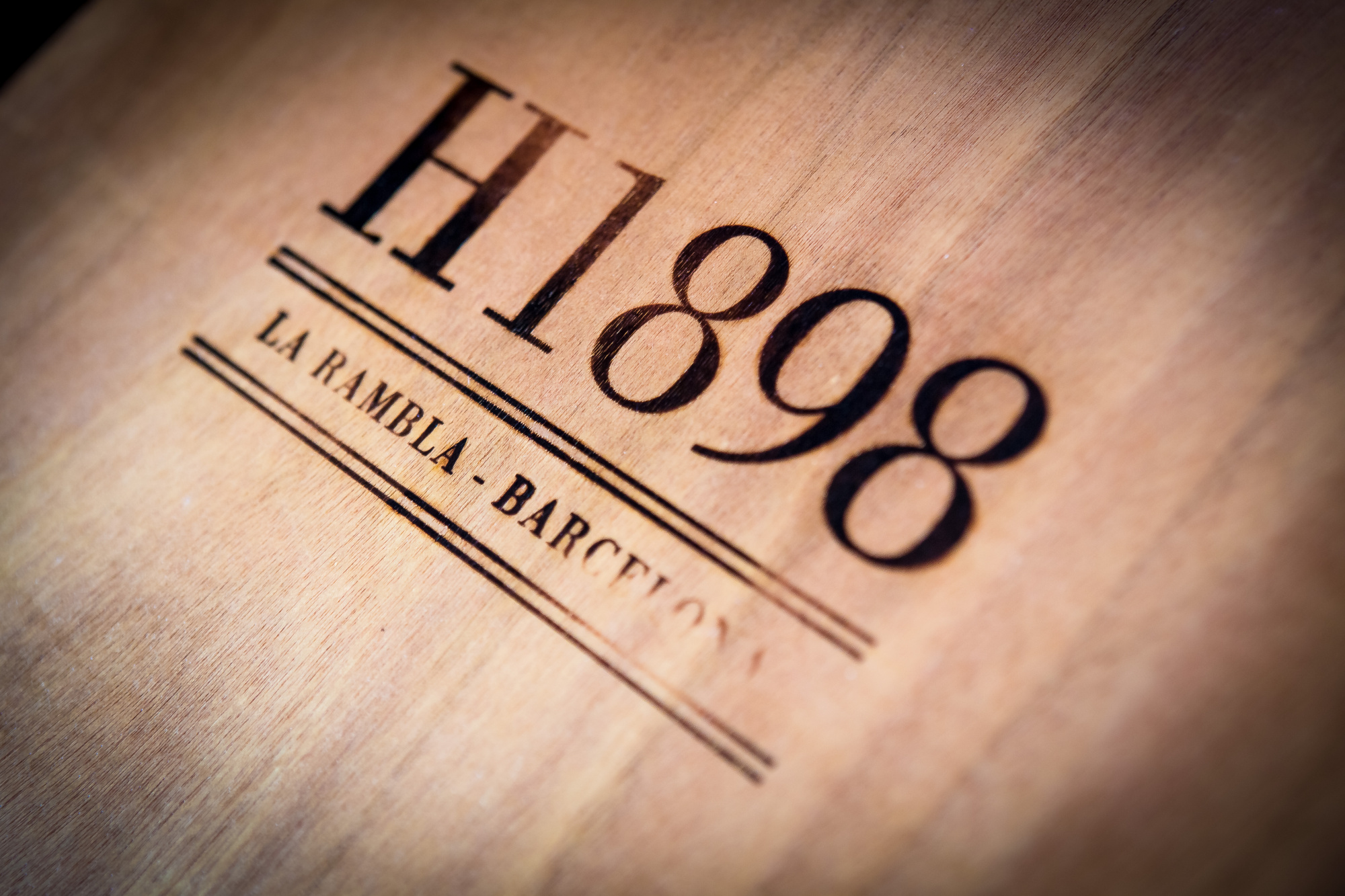 Se ve un logotipo con el texto “H1898” y “LA RAMBLA BARCELO” sobre un fondo claro.