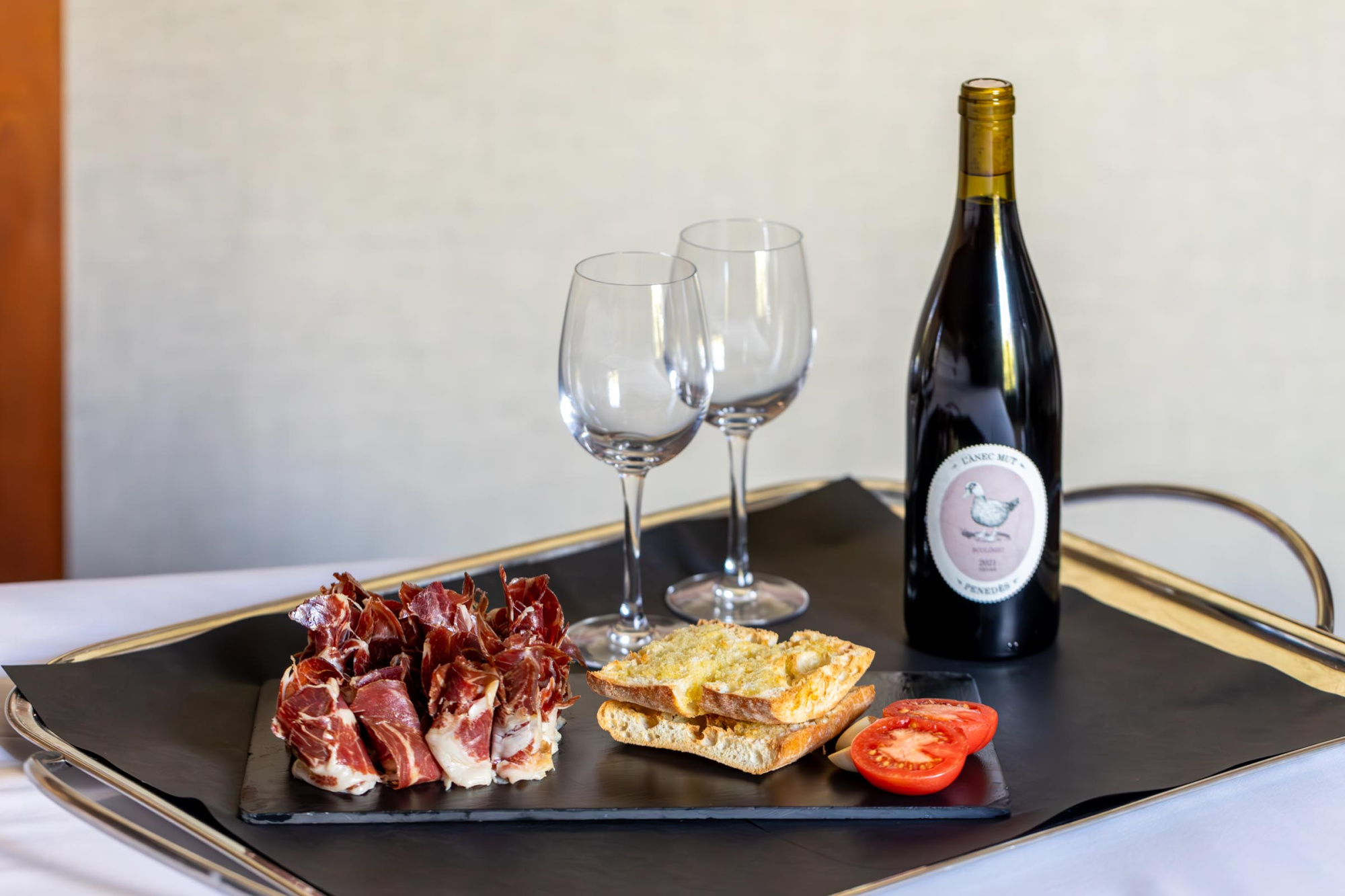 Una imagen que muestra una experiencia de maridaje entre jamón y vino, ideal para promocionar eventos gastronómicos en el hotel.