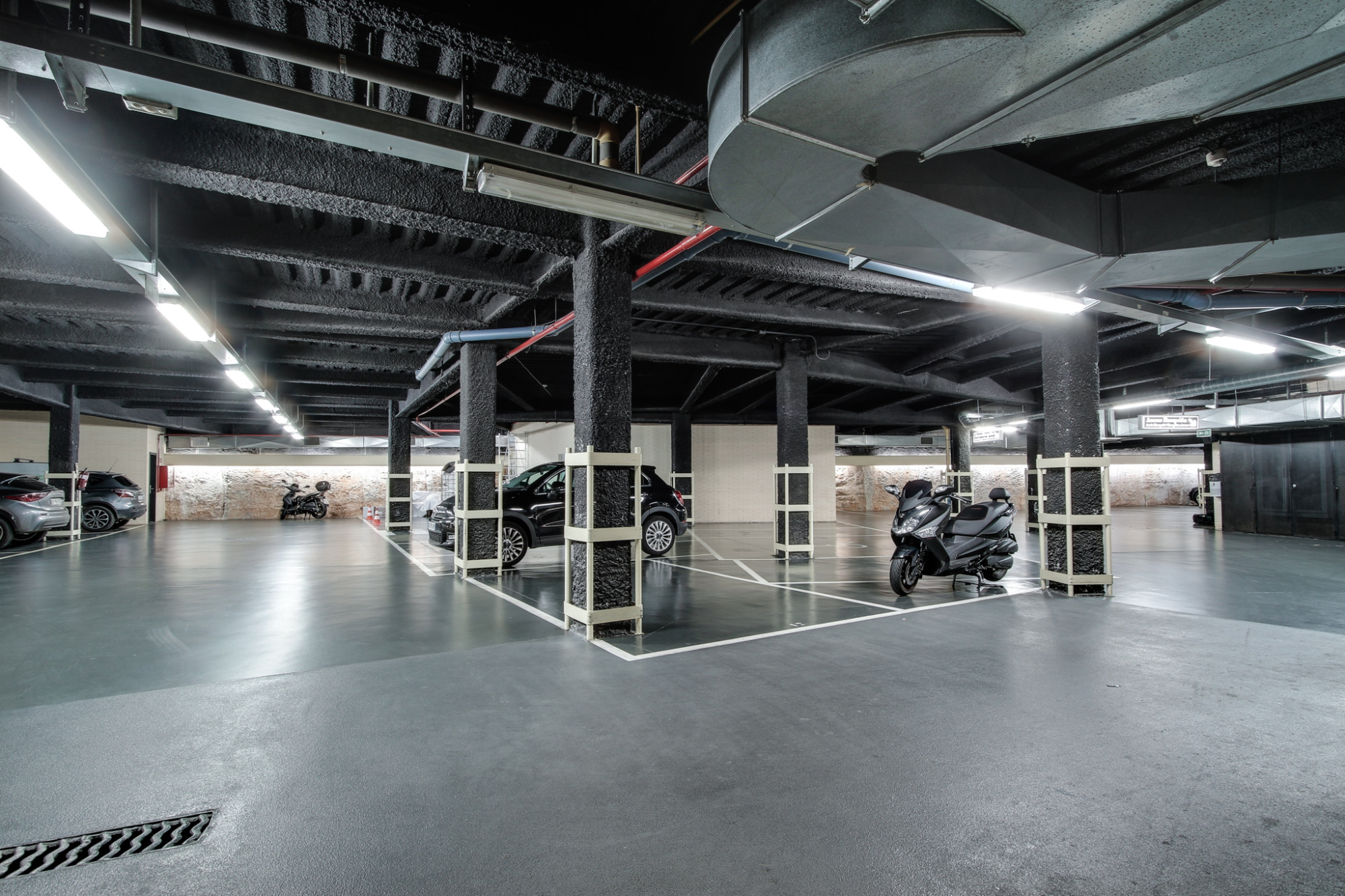 Imagen que muestra un área de estacionamiento privado con varias plazas delimitadas y señalización clara, ideal para huéspedes que buscan comodidad y seguridad.