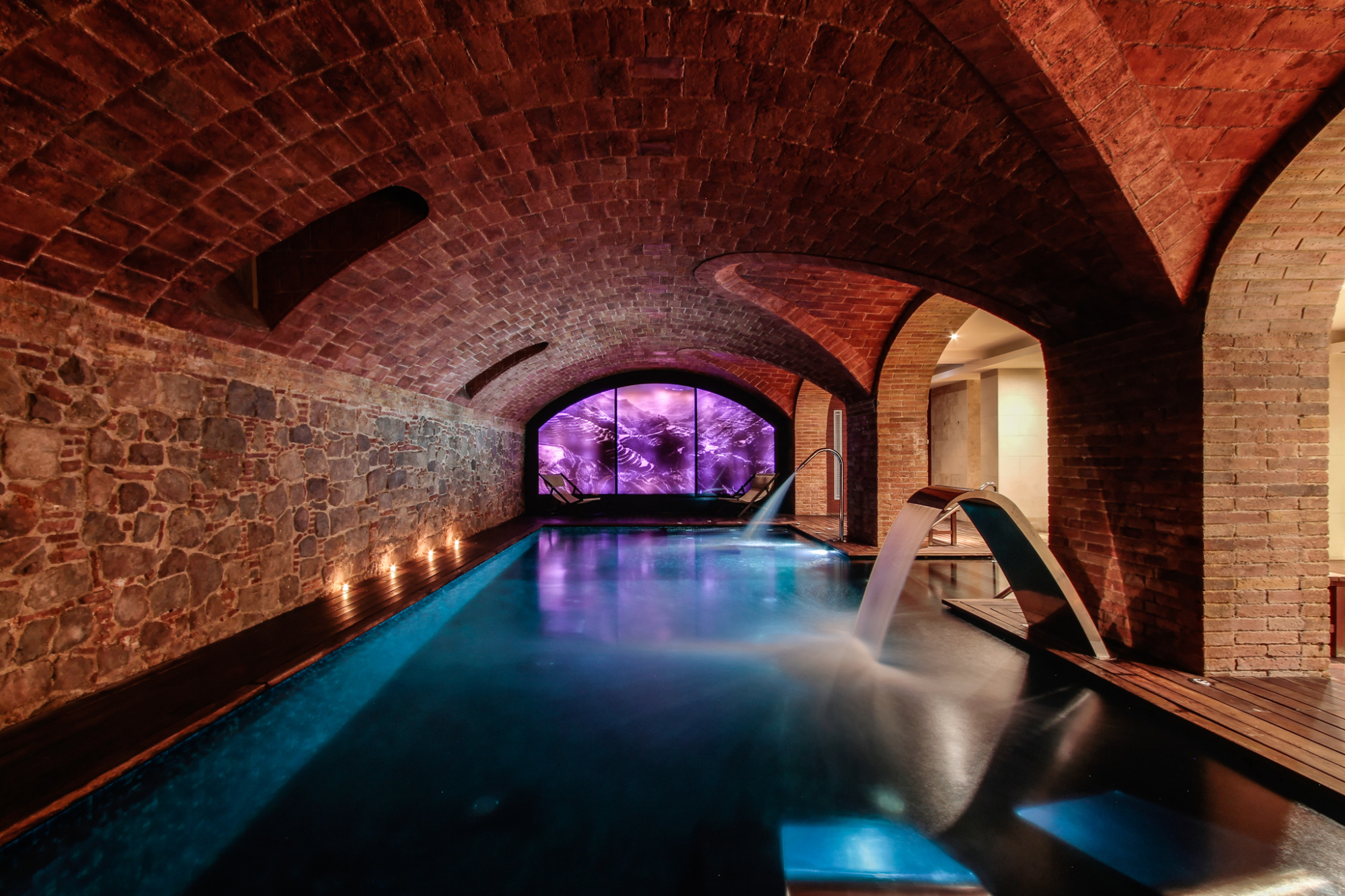 Área de spa moderna de diseño elegante, con una piscina interior de agua cristalina y un ambiente relajante, ideal para el bienestar y la tranquilidad de los huéspedes.