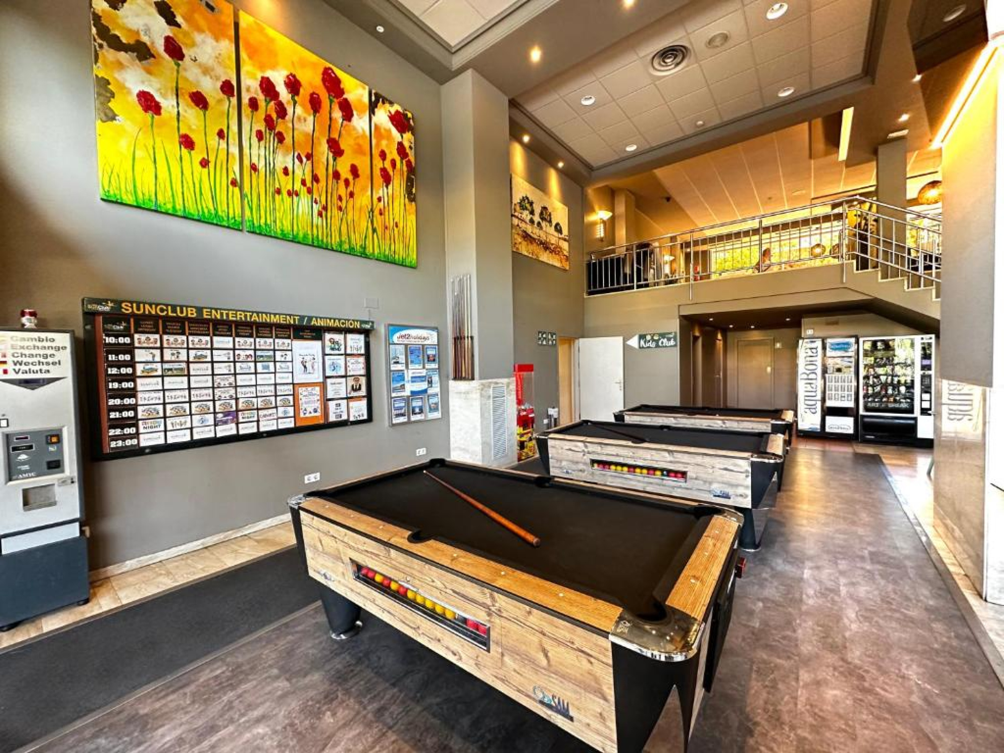 Una sala de juegos en el Aparthotel SunClub Salou que cuenta con varias mesas de billar, ideal para el entretenimiento de los huéspedes.