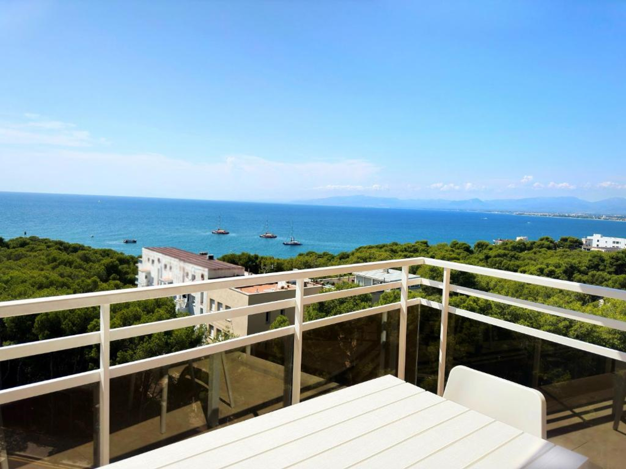 Un balcón con barandilla de metal y suelo de baldosas, ofreciendo una vista panorámica del océano en el Aparthotel SunClub Salou en Salou. La escena transmite tranquilidad y belleza natural, ideal para relajarse.