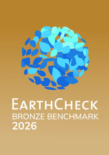 Earthcheck muestra el sello bronze benchmark 2026 sobre fondo beige.