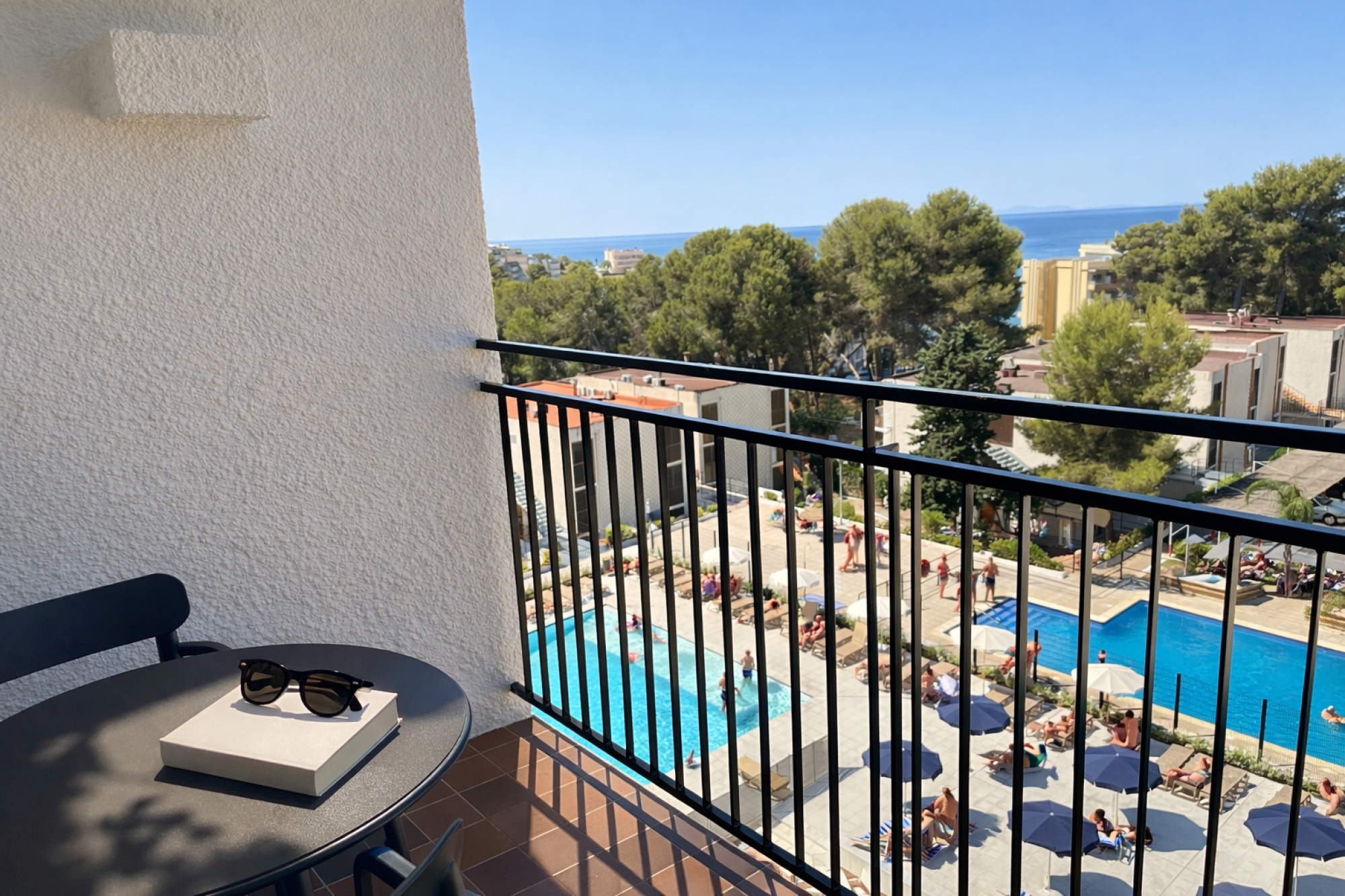 Una terraza con vista al mar que presenta una mesa como objeto principal, ideal para disfrutar del paisaje marítimo. La escena transmite tranquilidad y un ambiente relajante.