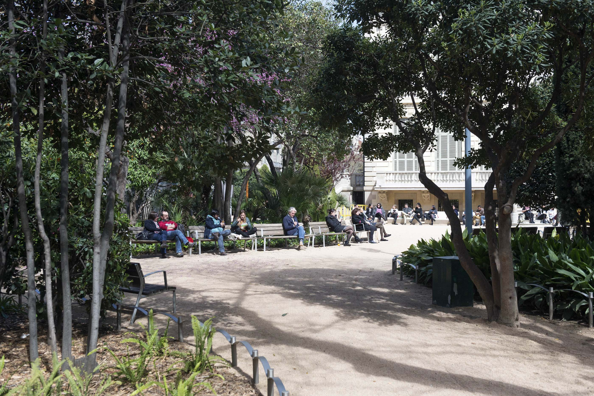 Imagen de los jardines del Palau Robert, mostrando áreas verdes bien cuidadas y caminos que invitan a pasear y disfrutar del entorno natural en un espacio cultural y de ocio.