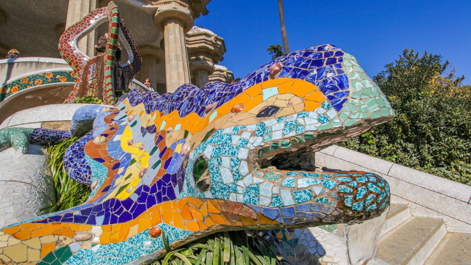 Vista del famoso Parque Güell en Barcelona, con sus coloridos mosaicos y arquitectura única diseñada por Antoni Gaudí, que refleja un estilo modernista y artístico.