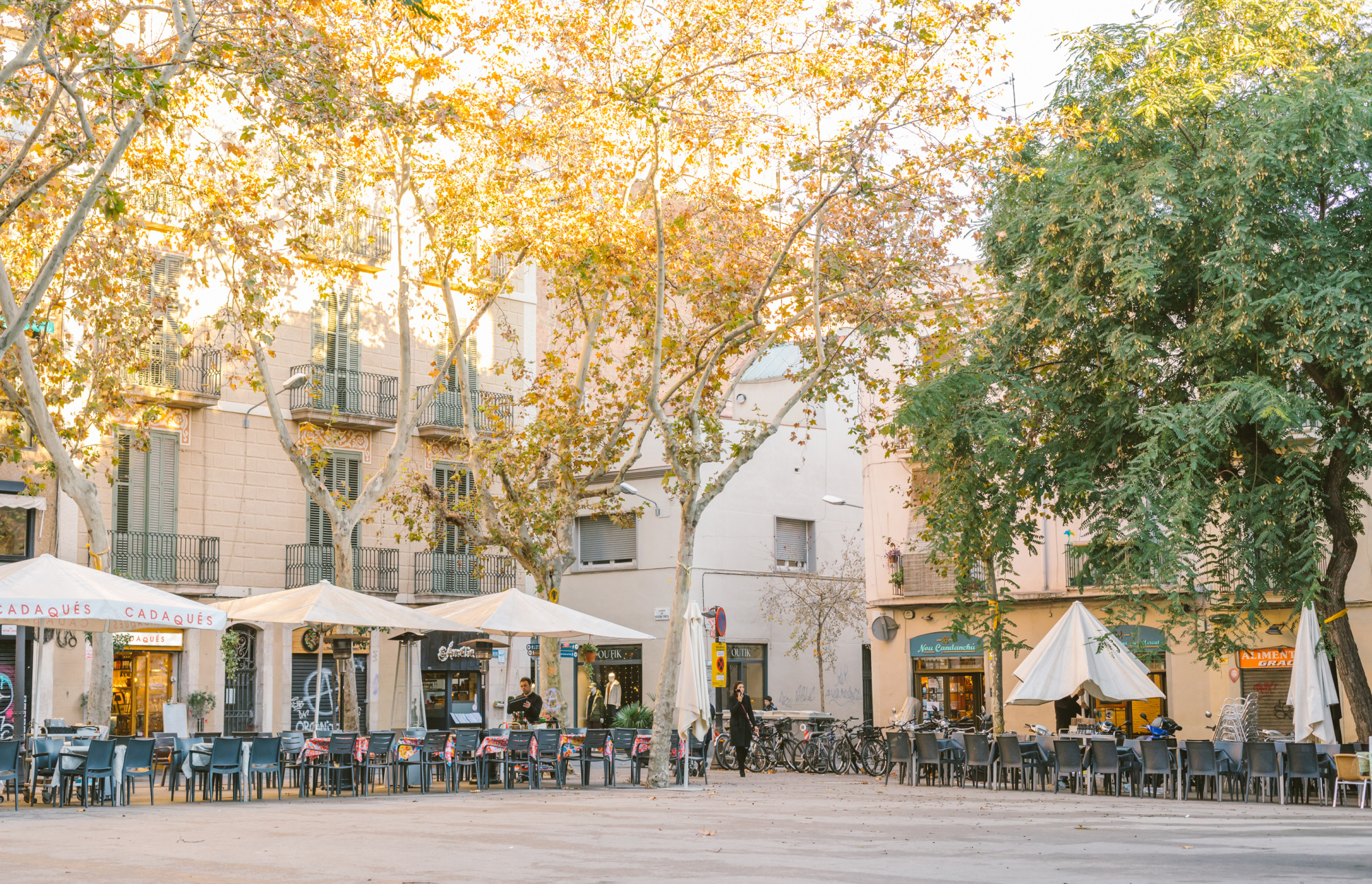 Una vista de una calle en el barrio de Vila de Gracia, con edificios residenciales de estilo clásico y coloridos, que reflejan la arquitectura típica del barrio en Barcelona.
