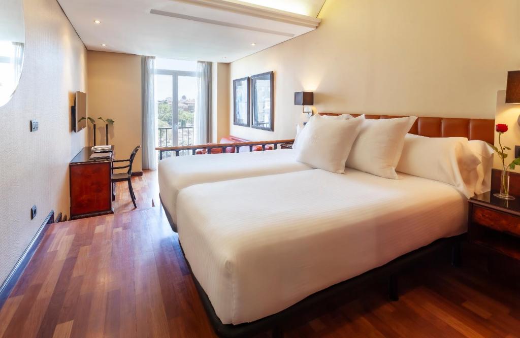 Habitación con cama doble y ventana con vistas a la ciudad