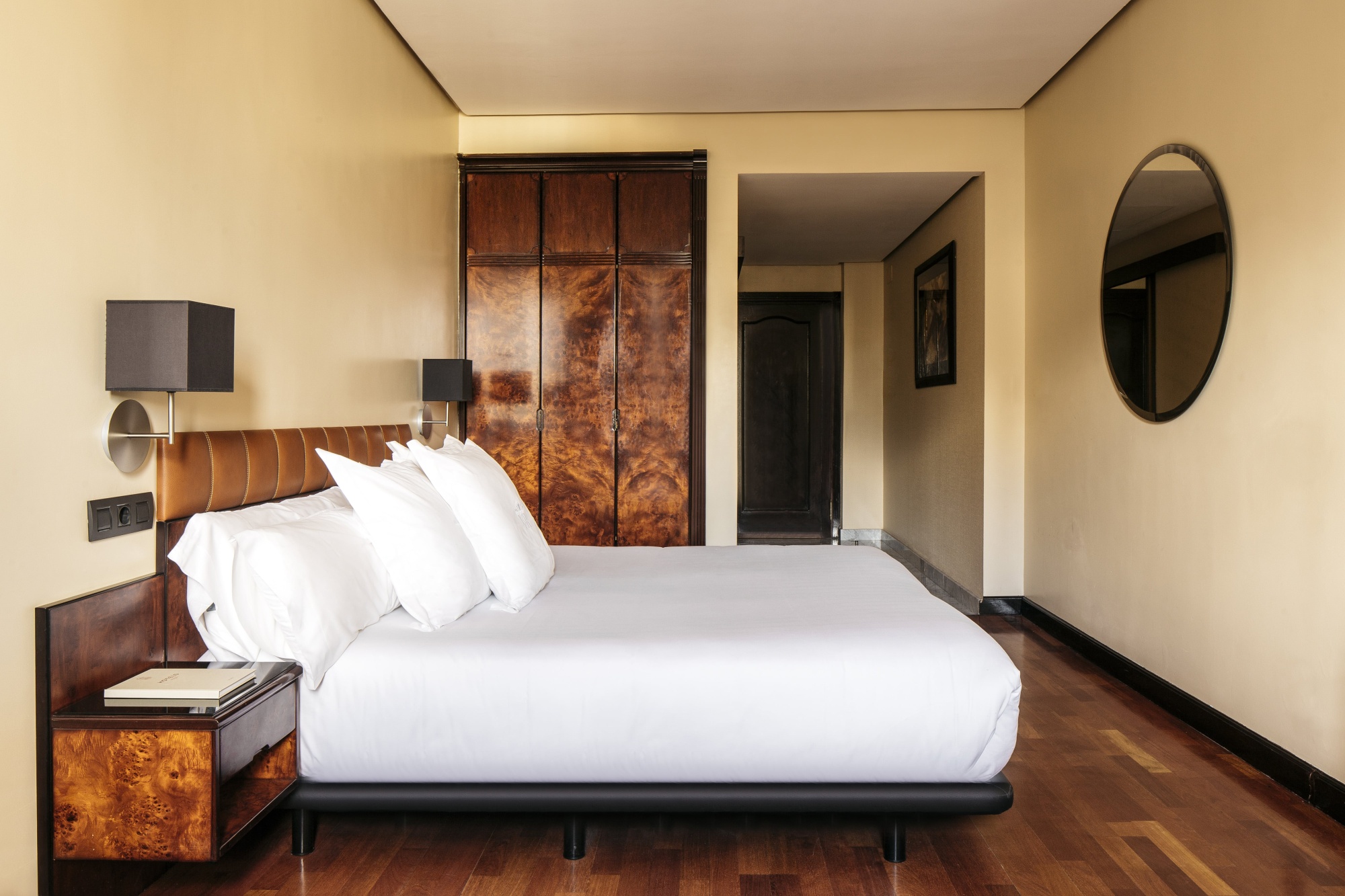 Un dormitorio con cama doble, mesitas laterales y un cuadro decorativo en la pared.