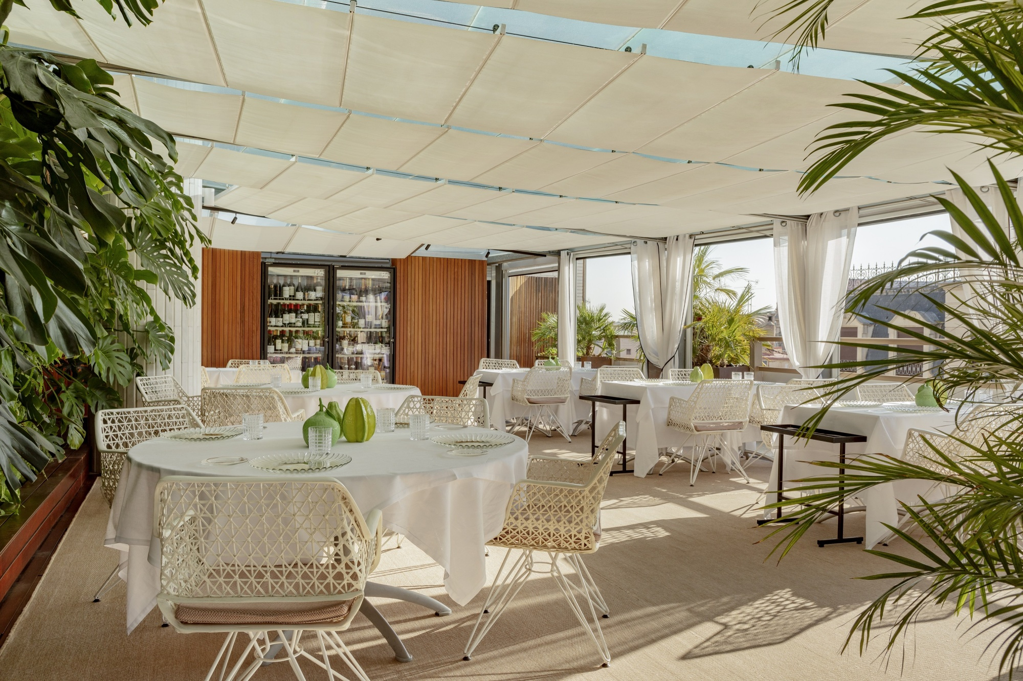 Una imagen del interior de un restaurante elegante con mesas y sillas modernas, decorado con tonos cálidos y detalles sofisticados que crean un ambiente acogedor y contemporáneo.
